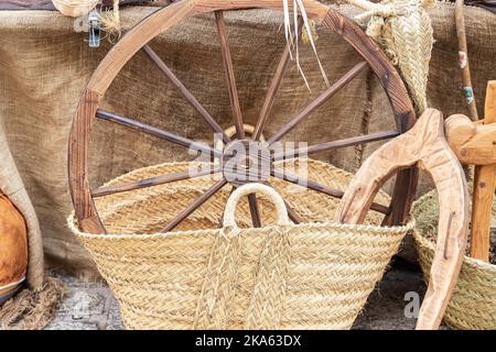 horizontal view in foreground of a wooden wheel inside a wicker basket Stock Photo