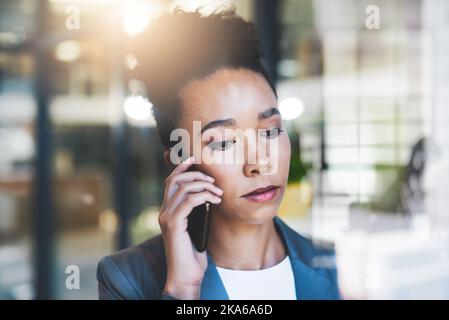 Calling a different department to help with this issue. an attractive young businesswoman on a call in her office. Stock Photo