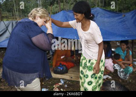 SUMATRA, INDONESIA 20150415. The norwegian Prime Minister Erna Solberg greets a woman from Orang Rimba Bujang Tampui tribe. People from Orang Rimba Bujang Tampui tribe in the rainforest on Sumatra Wednesday. The tribe is Indonesia's last rainforest nomads. This group of people are very vulnerable and threatened by deforestation, which takes place on a large scale in Indonesia. The norwegian Prime Minister Erna Solberg visited them Wednesday. She is on an official visit to Indonesia, where the Norwegian-Indonesian cooperation to save rainforests is a central theme. Photo: Heiko Junge / NTB scan Stock Photo