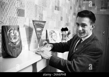 Edinburgh, Scotland - January 1965. Filephoto.  Roald 'Kniksen'  Jensen has become a professional footballer in Scotland with football club Heart of Midlothian. Roald 'Kniksen' Jensen  dries the dust off one of his prizes. Image of fiance in the background.   Stock Photo