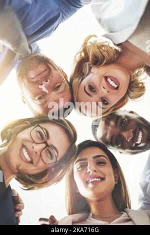 Together as one. coworkers looking down at the camera. Stock Photo