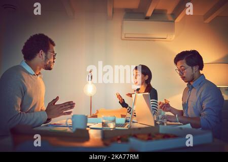 Business through the night. a group of designers working late in an office. Stock Photo
