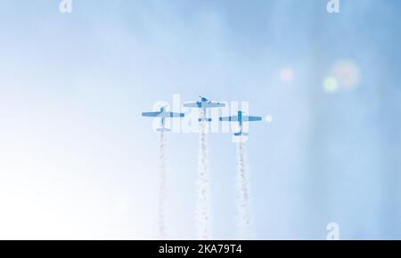 Silhouettes of training aircraft performing aerobatics on a clear sunny day. Stock Photo