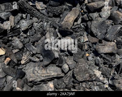 Burned black charcoal as background, top view Stock Photo