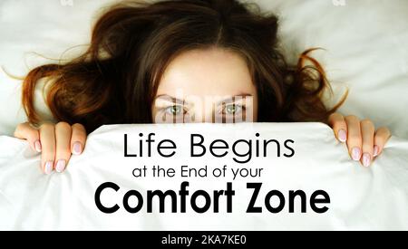 Life begins at the end of your Comfort Zone. The face of a woman under a blanket. Concept. The desire to hide from fear while remaining inactive. Stock Photo