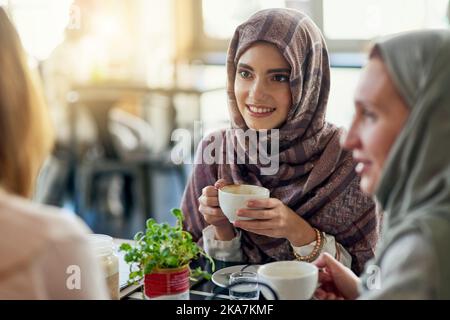 Nothing brings people together like coffee. a group of women chatting over coffee in a cafe. Stock Photo
