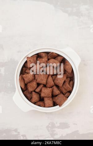 chocolate cereals in small white bowl on ceramic Stock Photo