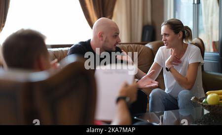 Young married couple of man and woman talk to psychologist at therapy session Stock Photo