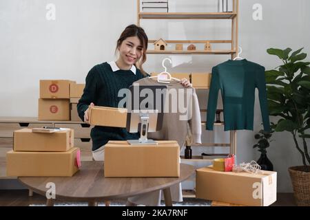 Asian woman freelancer sme business online shopping working with parcel box at home - SME business online and delivery concept Stock Photo