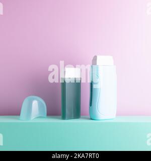 Wax depilation portable equipment on colored background. Depilatory heater and extra roll on wax catrtridge standing on decorative podium. Stock Photo