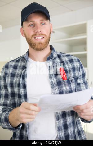 young engineer working on construction site and holding a blueprint Stock Photo