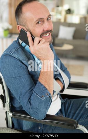 man in wheelchair talking on phone Stock Photo