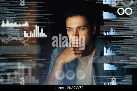 Trying to figure out the codes. a young computer programmer looking through data in the dark. Stock Photo
