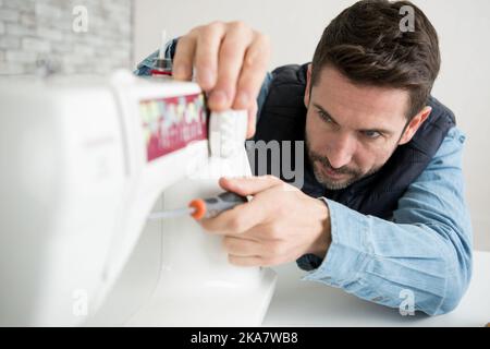 man repairing a sewing machine Stock Photo