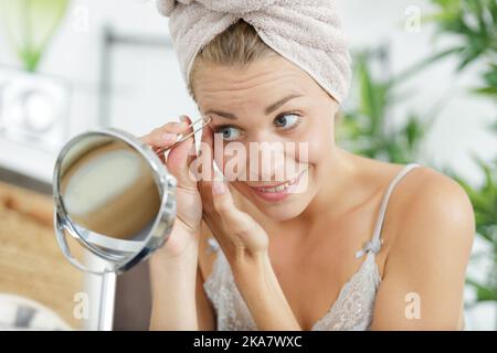 beautiful young woman does an eyebrow correction Stock Photo