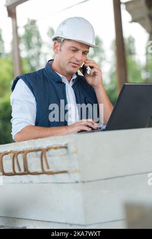 foreman looking at aptop on construction site Stock Photo
