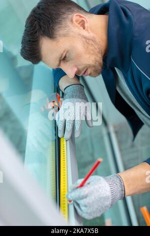 man installing cassette roller blinds on windows Stock Photo