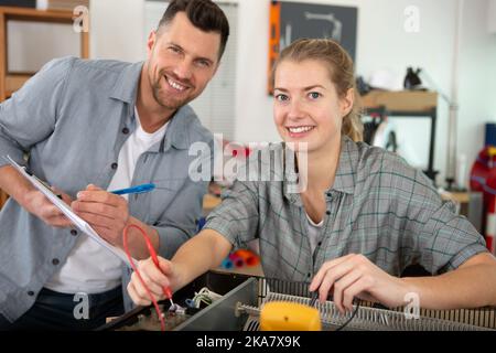 students of robotics preparing robot for testing in workshop Stock Photo