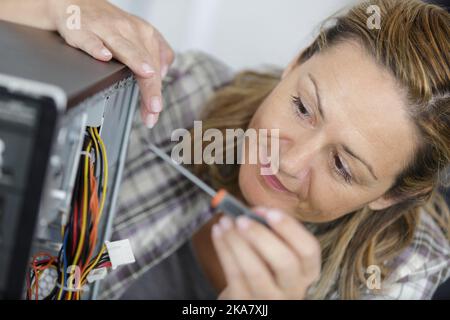 close view of female computer technician using a screwdriver Stock Photo