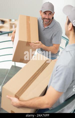 two mover wearing uniforms are unloading Stock Photo