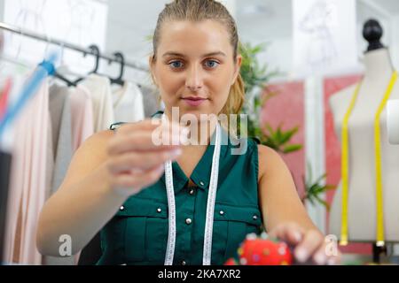 portrait of a young tailor holding needle Stock Photo