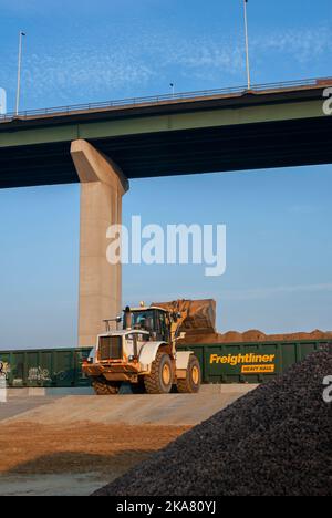 Caterplillar wheel loader loading agrregate wagons on a Freightliner freight train at the Lafarge Greenhithe site in Dartford, England. Stock Photo