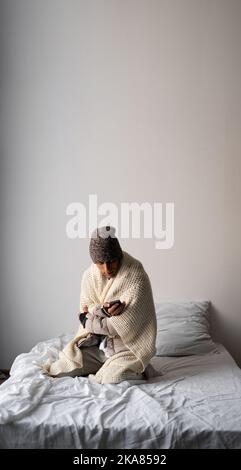 Young Man With Warm Clothing Feeling The Cold Inside House Stock