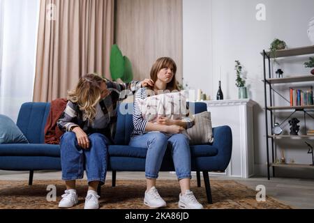 Mature woman soothes her adult daughter helps her survive divorce or break up. Mom supporting provide psychological aid show empathy. First love of fe Stock Photo