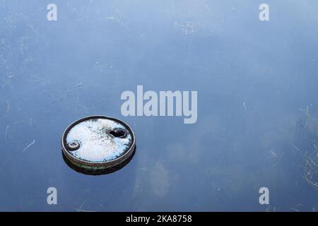 Old rusty oil barrel floating in polluted, contaminated. Stock Photo