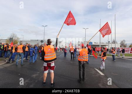 01 November 2022, Thuringia, Kölleda: Workers stand with flags at the entrance of the MDC Power plant during a warning strike by IG Metall. The union is demanding eight percent more pay for workers in the metal and electrical industries. Photo: Bodo Schackow/dpa Stock Photo