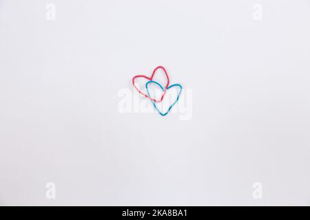 A blue and red paper clip in the shape of a heart on isolated white background. High quality photo Stock Photo