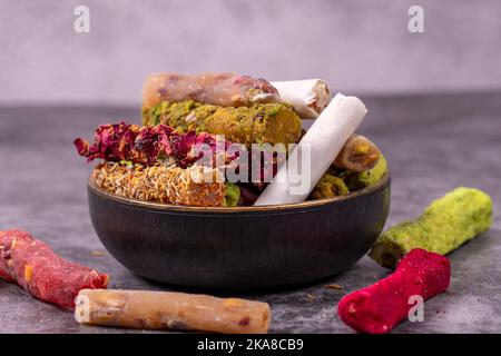 Mixed Turkish delight varieties on a dark background. Pistachio, hazelnut and fruit flavored Turkish delights. close up Stock Photo