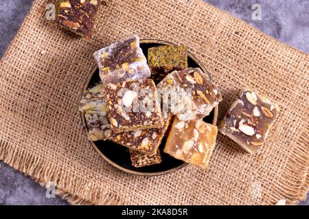 Mixed Turkish delight varieties on a dark background. Pistachio, hazelnut and fruit flavored Turkish delights. close up Stock Photo