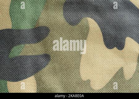 Simple dark green military camouflage pattern, synthetic army camo material background, generic structure, bag, clothing surface texture, flat textile Stock Photo