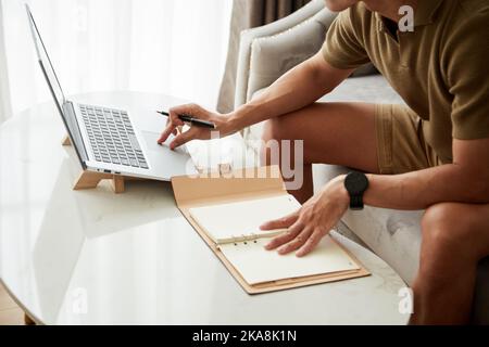 Cropped image of businessman checking e-mails and filling planner when working from home Stock Photo