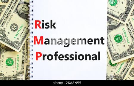 RMP risk management professional symbol. Concept words RMP risk management professional on white note on a background from dollar bills. Business RMP Stock Photo