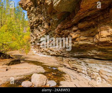 Small Creek Flowing Under Eroded Cliffs on The Devils Bathtub Trail, Spearfish Canyon, South Dakota, USA Stock Photo