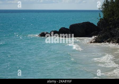 A beautiful view of the rock formations at cliffside of the west Whale Bay beach in bright sunlight in Southampton Parish, Bermuda Stock Photo