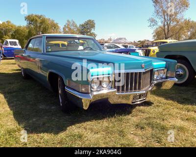 Chascomus, Argentina - Apr 9, 2022 - Old blue luxury Cadillac DeVille sedan four door 1970 in the countryside. Nature, grass, trees. Classic car show. Stock Photo