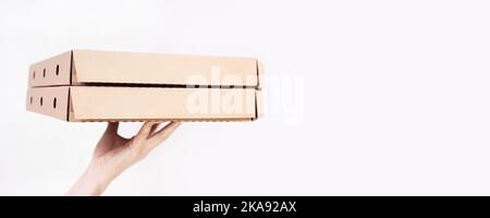 Girl holding two pizza boxes on her hand on a white background with copy space Stock Photo