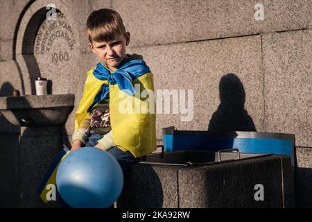 London, UK. March 26, 2022. A boy wearing a Ukraine flag at a demonstration against the Russian invasion of Ukraine in central London. Stock Photo
