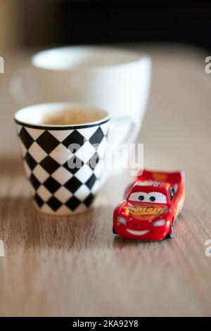 A vertical shallow focus of toy cars on a carpet - Lightning McQueen