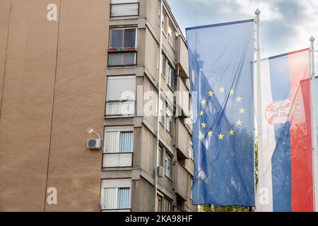 Picture of the flags of Serbia and the EU waiving in the air behind a sunny blue sky. The accession of Serbia to the European Union (EU) has been on t Stock Photo