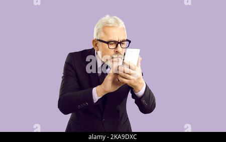 Aged businessman in glasses using cellphone Stock Photo