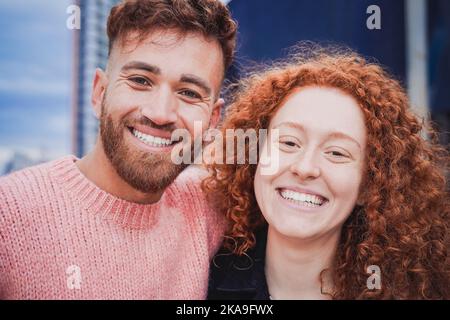 Happy red ginger hair brother and sister having fun doing selfie outdoor - Focus on faces Stock Photo