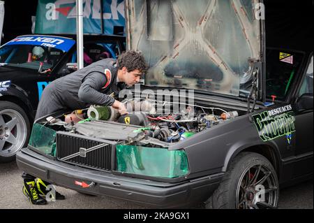 Young Mechanic checking the engine of his Volvo 940 before the race Stock Photo