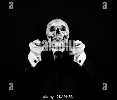 Black and White Portrait of Butler or Waiter in Dark Suit and White Gloves Holding Skull on Tray. Concept of Horror and Halloween. Stock Photo