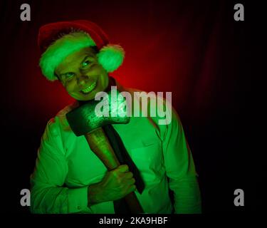 Portrait of Man Wearing Christmas Stocking Hat and Holding an Axe. Halloween and Christmas Horror Concept. Stock Photo