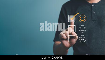 Customer service and Satisfaction concept ,Business people are touching the virtual screen on the happy smiley face icon to give satisfaction in servi Stock Photo