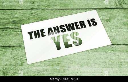 the words Answer is Yes on the card on wooden table. Positive solution business marketing concept. Stock Photo